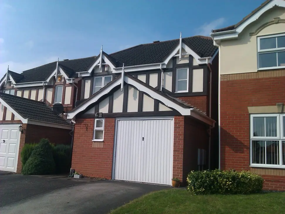 Mock Tudor style house with a painted white garage door and window frames